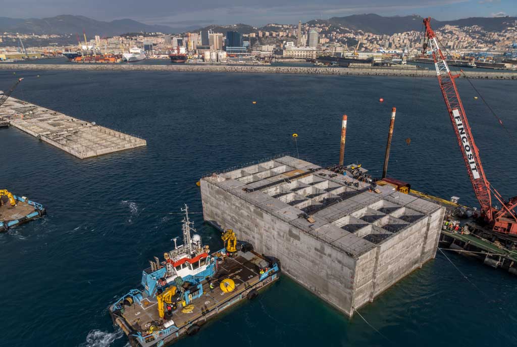 Cassone della nuova diga foranea del porto di Genova in fase di posa con i mezzi marittimi