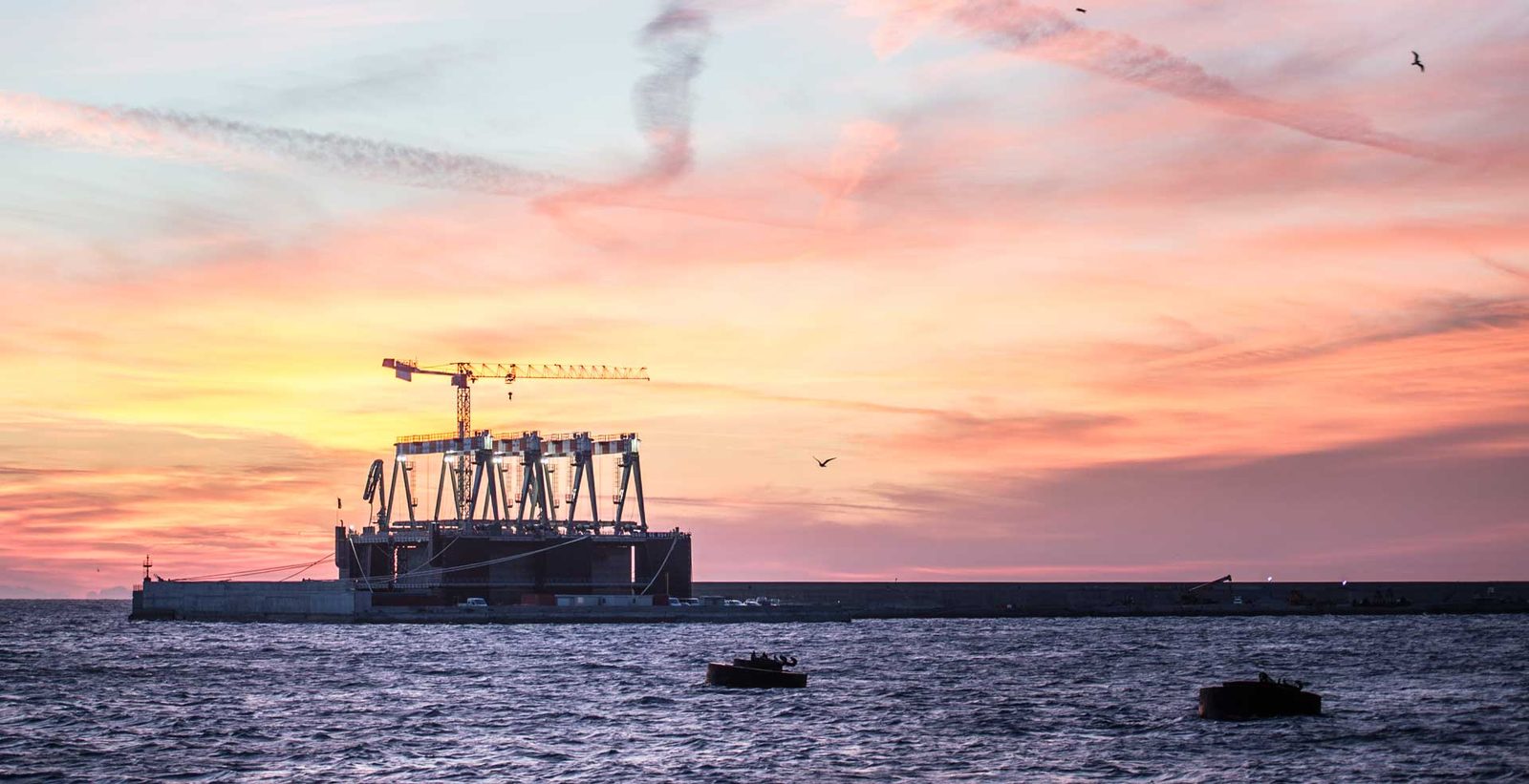 Porto di Vado Ligure al tramonto con le gru della piattaforma multifunzionale